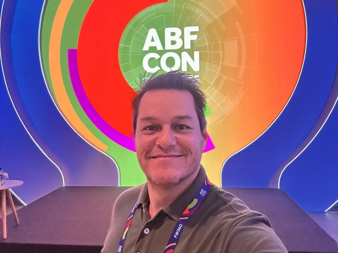 Alexandre Passarelli diante da identidade visual da ABF CON 2025